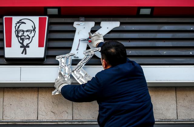 1984년 4월 국내에 첫선을 보인 KFC 국내 1호점인 종로점이 38년 만에 영업을 종료한 지난 1월 3일 직원이 서울 종로구 KFC 종로점에서 간판을 떼고 있다. 뉴시스
