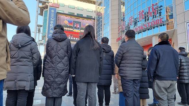 6일 오전 장쩌민 전 중국 국가주석의 추도대회가 방송되고 있는 베이징 왕푸징 거리의 대형스크린 앞에 주민들이 정렬해 있다. 베이징/최현준 특파원