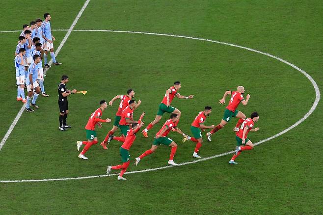 8강행이 확정되는 순간 모로코 선수들이 GK 부누에게 달려가고 있다. /AFP