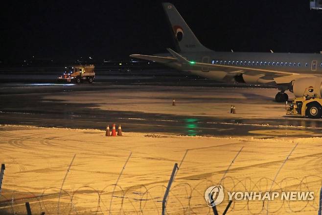 제주공항 제설 작업 (제주=연합뉴스) 박지호 기자 = 제주도에 대설특보가 발효된 18일 새벽 제설 차량이 제주공항 활주로의 눈을 치우고 있다. 2022.12.18 jihopark@yna.co.kr