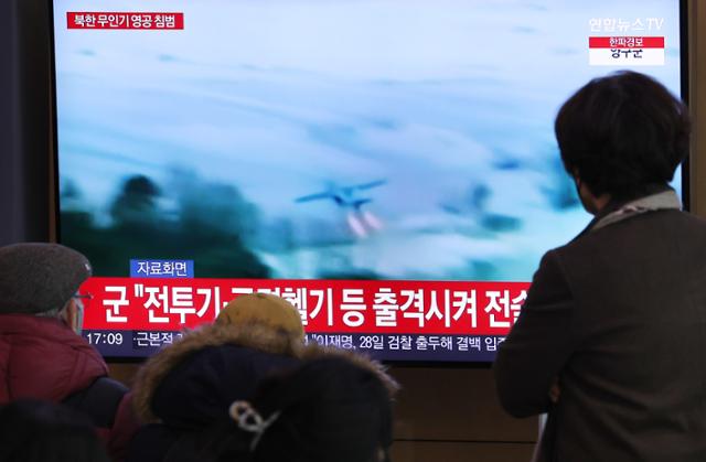 6일 서울역 대합실에서 시민들이 북한 무인기 영공 침범과 관련된 뉴스를 시청하고 있다. 연합뉴스