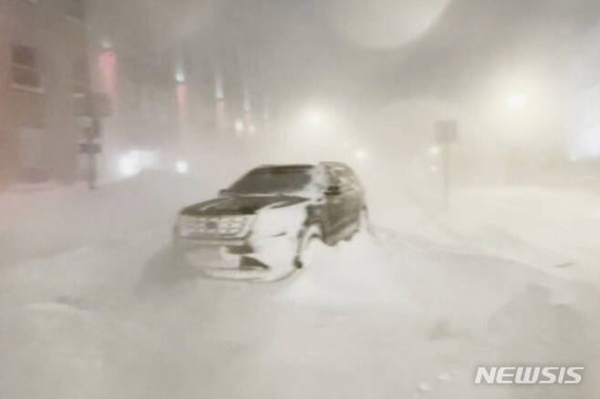 [버펄로=AP/뉴시스] 25일(현지시간) 미국 뉴욕주 버펄로시의 한 거리에 눈보라에 고립된 SUV 차량이 방치되어 있는 모습.