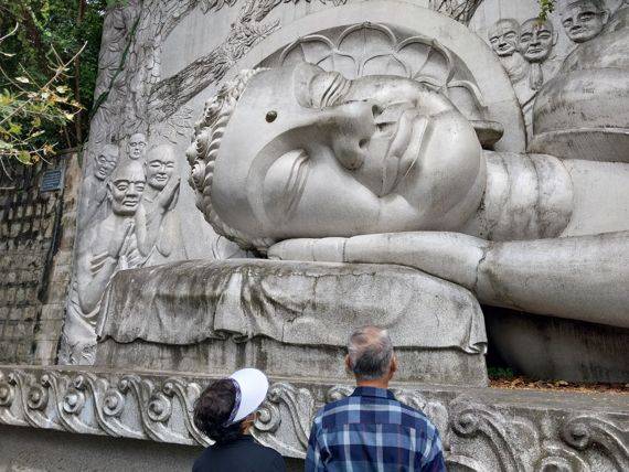 룽선사 중턱에 있는 누워있는 석불을 관광객이 보고 있다. /사진=이환주 기자
