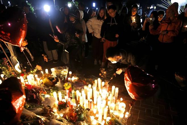 23일(현지시간) 미국 캘리포니아주 로스앤젤레스 인근 소도시인 몬터레이 파크 시청 앞에서 시민들이 이틀 전 발생한 총격사건 희생자들을 기리며 촛불을 켜고 있다. 몬터레이 파크 신화=연합뉴스