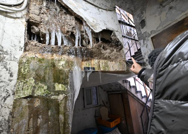 27일 서울 용산구 동자동 쪽방촌에서 한 주민이 사흘 전 무너져 내린 벽 틈으로 얼어 있는 고드름을 가리키고 있다. 고영권 기자