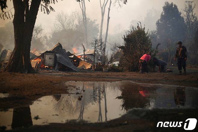 2일(현지시간) 칠레 키용 시골 지역에서 산불이 발생해 민가에까지 불이 옮겨붙었다. 무너지고 그을린 주택들에서 대피한 주민들이 현장 근처에 남아 있다. ⓒ 로이터=뉴스1 ⓒ News1 권진영 기자