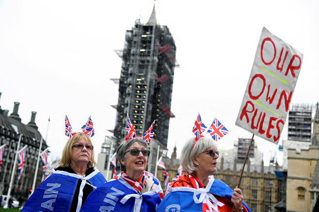 영국의 유럽연합 탈퇴(브렉시트) 발효를 하루 앞둔 2020년 1월31일 영국 런던의 의회 광장에서 브렉시트에 찬성하는 시민들이 영국 국기를 머리에 꽂고 “우리의 자치”라고 쓴 손팻말을 들고 지지 시위를 하고 있다. 런던/로이터 연합뉴스