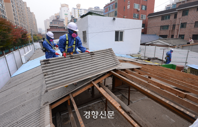 서울 영등포 한 주택에서 2012년 노동자들이 슬레이트 지붕을 철거하고 있다. 경향신문 자료사진