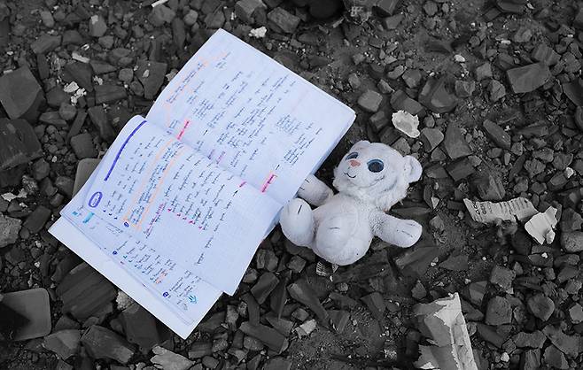 러시아의 우크라이나 침공 이틀째인 2022년 2월 26일 러시아의 미사일에 맞은 키이우 로바노프스키 애비뉴 아파트의 블록 옆 잔해 사이에 어린이의 장난감과 공책이 놓여 있다. 게티이미지