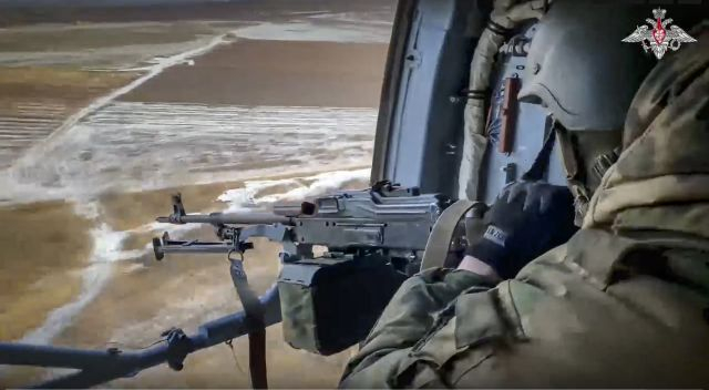 러시아 국방부가 지난달 17일(현지시간) 공개한 영상의 일부. 러시아군 병사가 우크라이나의 한 상공을 비행하는 헬리콥터에서 기관총을 조준하고 있다. AP연합뉴스
