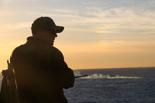 미국 해군의 카터 홀 함의 지휘관이 지난 4일 중국의 '스파이' 풍선 잔해가 떨어진 곳으로 추정되는 바다를 관찰하고 있다./로이터 연합뉴스