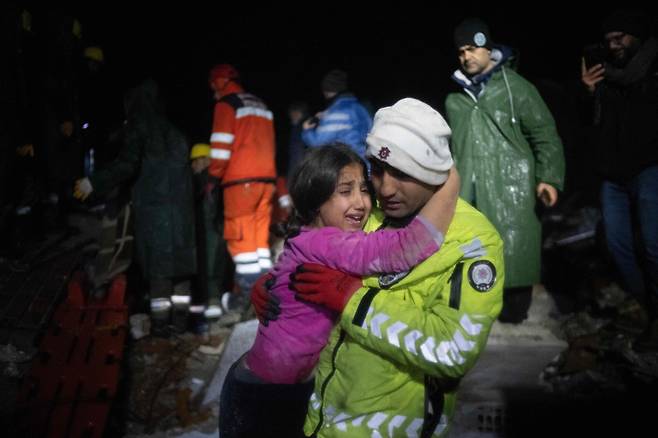 제케리야 일디즈 경찰관이 6일(현지 시각) 규모 7.8의 지진이 남동부를 강타한 후 하타이의 잔해에서 딸을 구한 후 포옹하고 있다. / AFP=연합뉴스