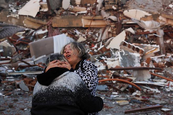 강진 발생 다음날인 7일(현지시간) 지진으로 붕괴한 튀르키예 하타이의 건물 잔해 앞에서 두 사람이 서로 끌어안고 있다. 로이터연합뉴스