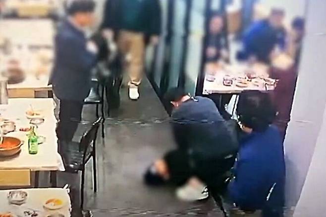 지난 6일 정오쯤 전북 군산시 한 식당에서 50대 손님이 식사 도중 갑작스러운 심정지로 바닥으로 떨어져 쓰러지자 이 식당 종업원 김윤하(36)씨가 심폐소생술을 시도하고 있다. 식당 폐쇄회로(CC)TV 녹화 화면 캡처