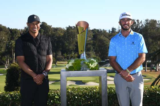 Max Homa of the United States, right, stands with the trophy and tournament host Tiger Woods after defeating Tony Finau of the United States, in a playoff to win the Genesis Invitational at Riviera Country Club on Feb. 21, 2021 in Pacific Palisades, California. [GETTY IMAGES]