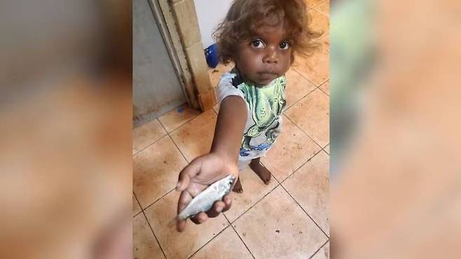 라자마누의 한 아이가 바닥에서 주운 물고기를 들고 있다./페이스북