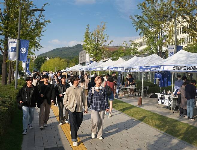 Students browse booths at Yonsei University’s Muak Festival on Thursday, at the university’s Sinchon campus in central Seoul. It is the first time in three years the university has held an offline campus festival. [ALLAND DHARMAWAN]