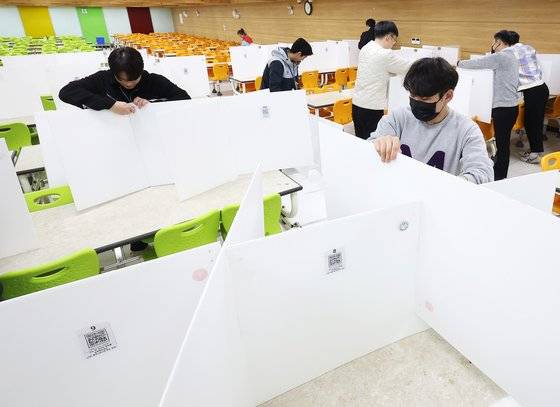 지난달 27일 경기도 수원시 팔달구 삼일공업고등학교에서 교직원들이 급식실 칸막이를 치우고 있다. 연합뉴스