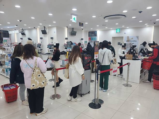 8일 오후 서울 중구 다이소 명동역점의 계산대 앞에 대기줄이 만들어졌다. 외국인 여행객들은 키오스크 셀프 결제가 익숙하지 않아 직원이 응대하는 계산대를 선호했다./채제우 기자
