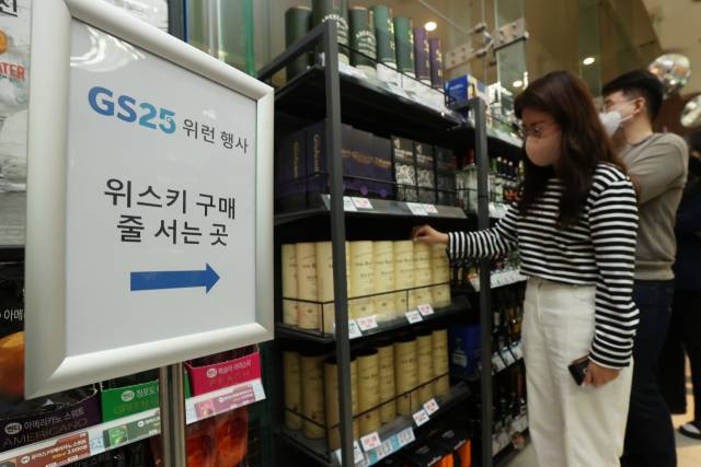 위스키 오픈런 행사가 시작된 10일 서울의 한 GS25에서 고객이 구매를 하고 있다. /연합뉴스