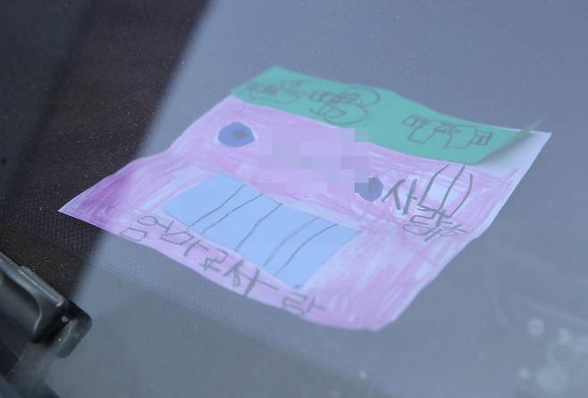 지난 18일 인천시 미추홀구 한 주택에서 숨진 채 발견된 일가족 소유 차량에 아이가 쓴 것으로 보이는 쪽지가 놓여 있다. [연합]