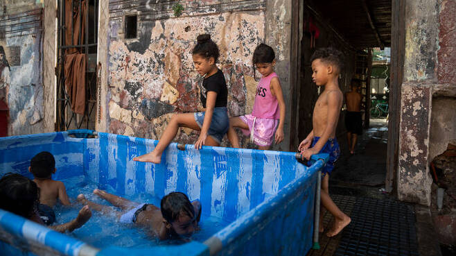 부에노스아이레스시 라보카 지역 길가에 설치된 간이 수영장에서 아이들이 더위를 식히는 모습