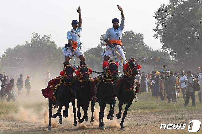 인도 펀자브주 암리차르에서 시크교도들이 시크교 축제 '반디 초르 디바스'에서 말을 타며 곡예를 펼치고 있다. 2022.10.25 (사진은 기사 내용과 무관) ⓒ AFP=뉴스1 ⓒ News1 박재하 기자