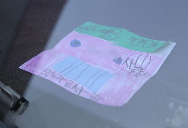 지난 18일 인천시 미추홀구 한 주택에서 숨진 채 발견된 일가족 소유 차량에 아이가 쓴 것으로 보이는 쪽지가 놓여 있다. 연합뉴스