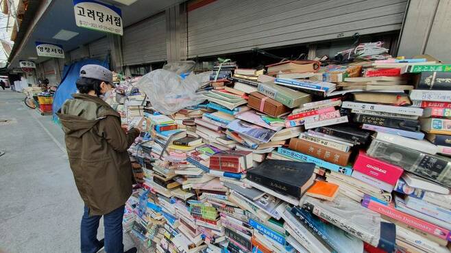 대전 중앙시장 중앙메가프라자 구역에 있는 헌책방에서 한 행인이 가게 앞에 쌓인 책들을 살펴보고 있다. 사진=김원준 기자