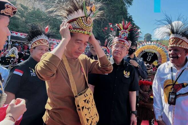 조코 위도도 인도네시아 대통령이 21일 파푸아주 자야프라에서 개최된 ‘파푸아 청년 창조 허브’ 출범식에 참석해 파푸아 전통 모자를 착용해 보고 있다. 자유푸라=AFP연합뉴스