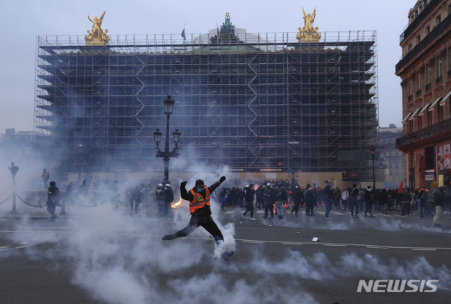 지난 23일(현지시간) 프랑스 파리에서 열린 연금개혁 반대 시위에서 한 참가자가 경찰이 쏜 최루탄을 발로 걷어차고 있다. 최루탄은 현대에도 대규모 군중집회를 해산시키기 위한 목적으로 곳곳에서 사용되고 있다.  AP 뉴시스