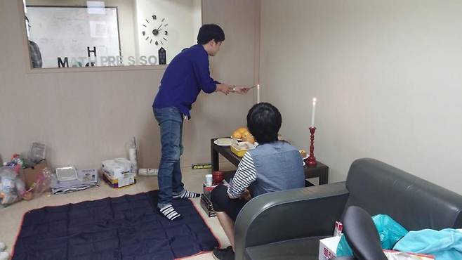 매스프레소 이종흔 공동창업자가 창업 초기 연남동 반지하에서 고사를 지내면서 초에 불을 붙이고 있다. /매스프레소 제공