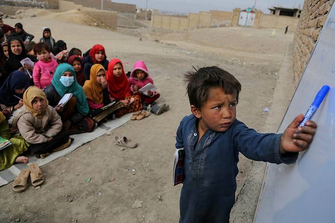 아프가니스탄 한 어린이가 야외 교실에서 수업을 받던 중 칠판에 쓴 글을 말하고 있다. 카불/EPA 연합뉴스