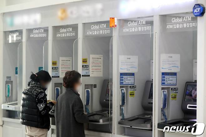 서울 시내 한 건물에 설치된 은행의 현금인출기(ATM)에서 시민들이 입출금을 하는 모습. 2022.12.27/뉴스1 ⓒ News1 황기선 기자