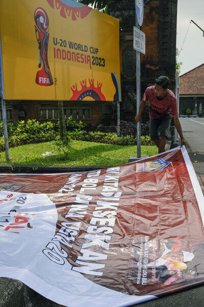 인도네시아의 한 노동자가 발리 덴파사르 도로 인근에 설치된 2023 국제축구연맹(FIFA)의 20세 이하(U-20) 월드컵 개최 관련 현수막을 철거하고 있다. 덴파사르=EPA연합뉴스
