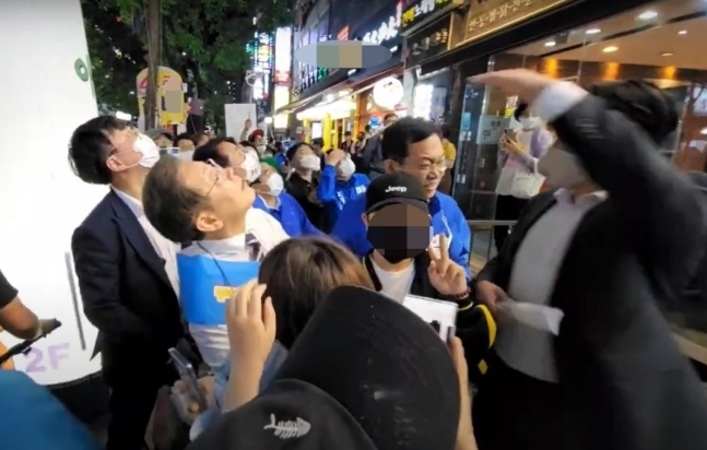 지난해 5월20일 당시 인천 계양을 국회의원 보궐선거에 출마한 이재명 더불어민주당 후보가 거리 유세를 하던 중 철제그릇이 날아온 곳을 바라보고 있다. 이재명 유튜브 영상 갈무리