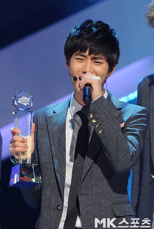 엑소가 2013년 8월 엠카운트다운에서 1위를 차지했다. 수호가 트로피를 들고 열창하고 있다.