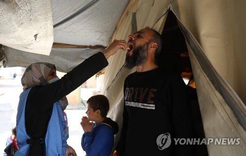 (EPA 이들립=연합뉴스) 시리아 북서부 이들립 지역의 난민 캠프에서 지난 3월 초 보건당국자가 콜레라 예방 접종을 하고 있다.