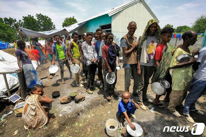 10일(현지시간) 수단 동부 게다레프 지역 바순다의 한 마을에서 에티오피아 난민들이 음식을 얻기 위해 줄을 서고 있다. ⓒ AFP=뉴스1 ⓒ News1 구진욱 기자