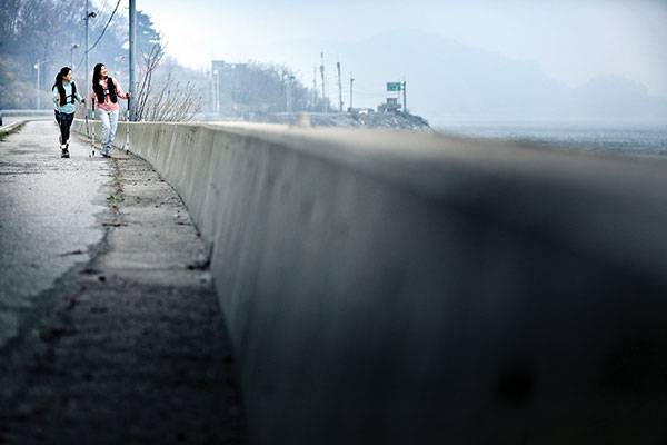 건평항에서 외포항으로 이어진 강화 나들길을 걷는 이민정·최서윤(오른쪽)씨. 석모도가 맞은편에 있어 망망대해는 아니지만 바다를 곁에 두고 걸을 수 있다.