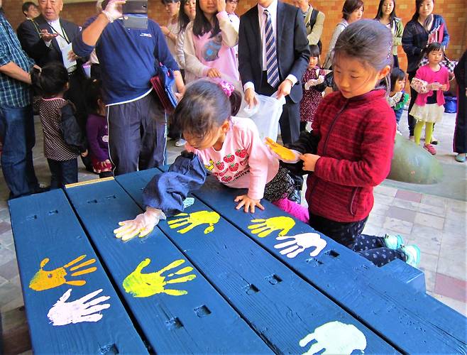 2014년 중국인을 비하하는 낙서로 가득했던 단지 안 벤치. 이듬해 일본과 중국 주민들이 합심해 낙서를 지운 뒤 핸드프린팅을 남겼다.