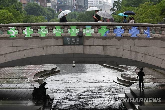 비가 내린 18일 오후 시민들이 서울 중구 청계광장에서 모전교를 건너거나 다리 밑에서 비를 피하고 있다. [출처=연합뉴스]