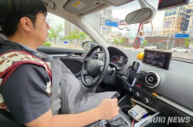체험복을 입고 운전대를 잡은 기자.