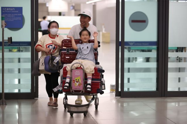 29일 오후 괌을 떠나 인천국제공항 제1여객터미널을 통해 입국한 한 가족이 활짝 웃으며 입국장에 들어서고 있다. 연합뉴스