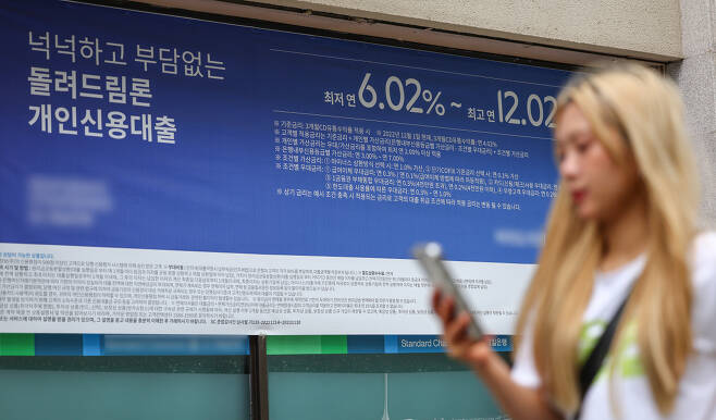 서울 한 시중은행의 대출 안내문 앞을 시민이 지나가고 있다.[연합]