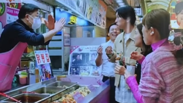 일본 개그맨 야마소에 히로시가 자신이 사용한 꼬치로 매대의 음식을 찍어 먹으려 하자 가게 사장이 이를 저지하고 있다. 일본 TBS 방송화면 캡처