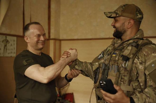 올렉산드르 시르스키 우크라이나 지상군 사령관이 3일(현지시간) 우크라이나 동부 격전지 바흐무트 전선의 우크라이나군 부대를 방문하고 한 군인과 손을 맞잡고 있다. / 사진=올렉산드르 시르스키 텔레그램