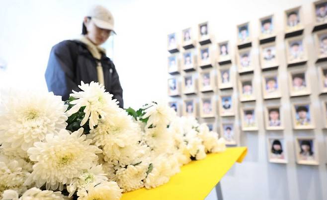 세월호 참사 9주기인 지난 4월 16일 오후 서울 중구 서울시의회 세월호 기억공간을 찾은 한 시민이 헌화한 뒤 묵념하고 있다. 이날 16시16분 기억공간 앞에서 시민기억식이 열렸다.(사진=연합뉴스)