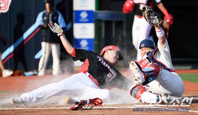 우익수 윤동희 홈 송구를 잡은 포수 유강남이 주자 이우성과 홈에서 승부를 펼치고 있다.