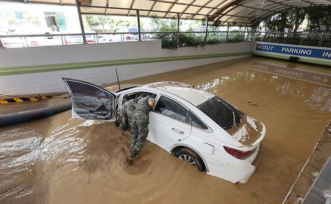 지난해 9월 태풍 '힌남노'의 영향으로 지하주차장이 물에 차 주민 7명이 목숨을 잃은 경북 포항시 남구의 한 아파트. 군인들이 물에 잠긴 차량 내부를 수색하고 있다. /남강호 기자